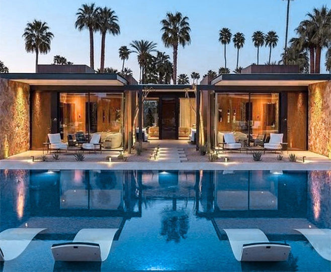 Modern house with a pool and palm trees at sunset