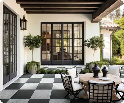 Outdoor patio with checkered floor, black-framed glass door, and outdoor furniture.