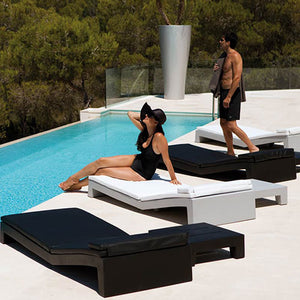 Black and white patio chaise lounge chairs and swimming pool