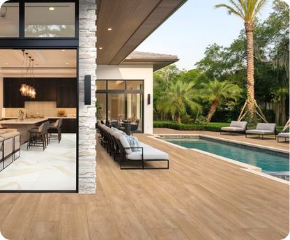 Modern outdoor living space with pool, lounge chairs, and kitchen.