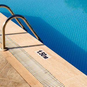 Swimming pool with porcelain pool coping and depth safety marker "1.50 M"