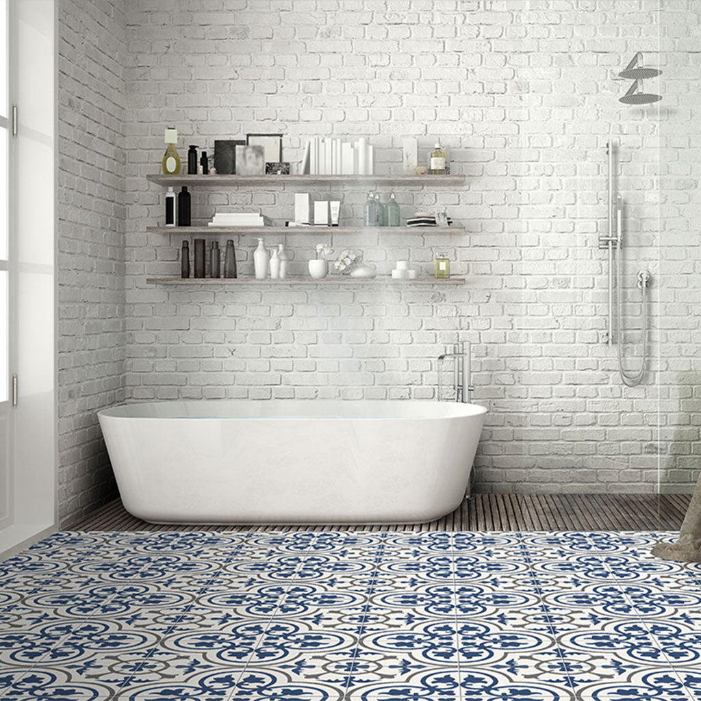 White and blue patterned tile on bathroom floor with white brick tile on bathroom shower wall