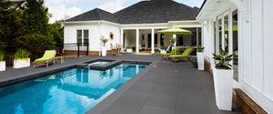 Dark grey outdoor porcelain pavers and swimming pool with patio furniture