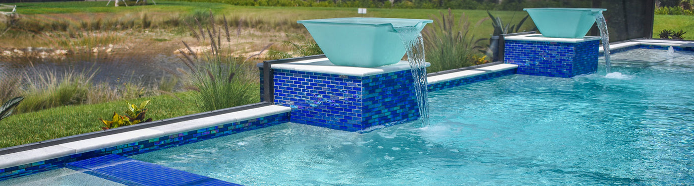 Swimming pool with blue glass waterline tile and water bowl features