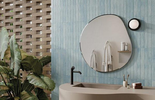 aqua bathroom tile with a mirror and sink with plant in the corner