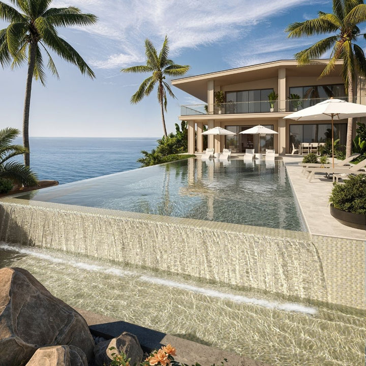 Luxury villa with an infinity pool overlooking the ocean, surrounded by palm trees.