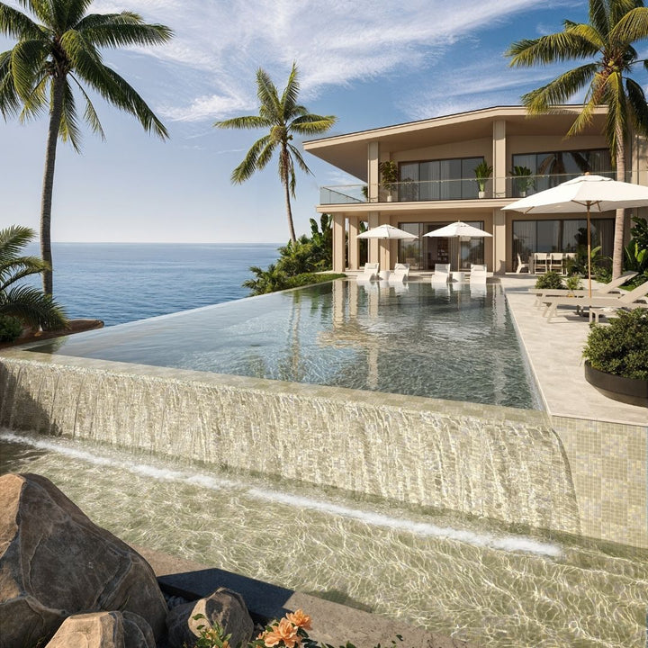 Luxury villa with an infinity pool overlooking the ocean, surrounded by palm trees.