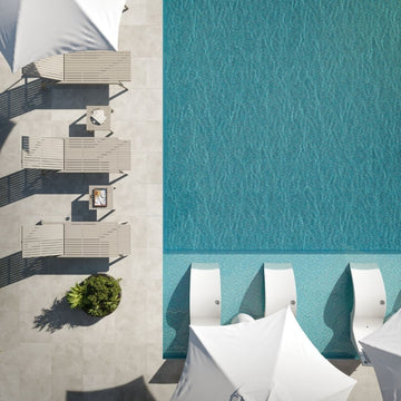Top-down view of outdoor furniture by a pool with water pattern.