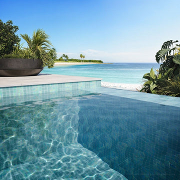 Pool area with tiled edge and ocean view
