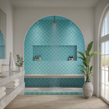 Modern bathroom with a blue tiled shower area and a large window.