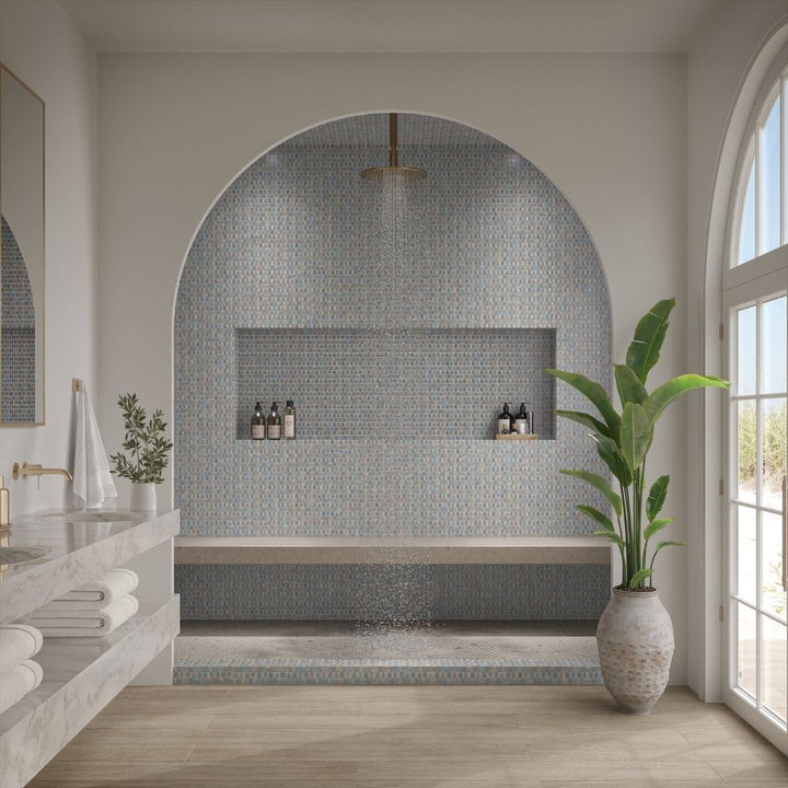 Modern bathroom with mosaic tile wall, plant, and natural light