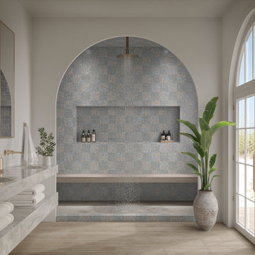 Modern bathroom with tiled shower area, sink, and plant