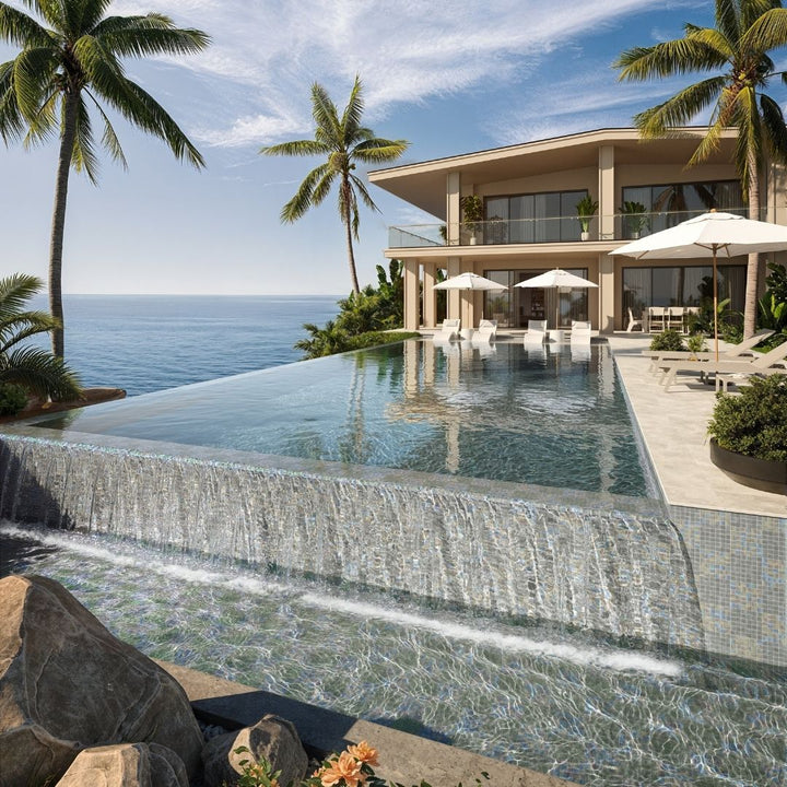 Luxury villa with an infinity pool overlooking the ocean, surrounded by palm trees.
