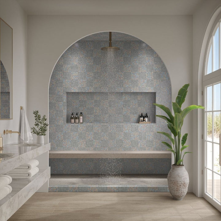 Modern bathroom with tiled shower area, sink, and plant