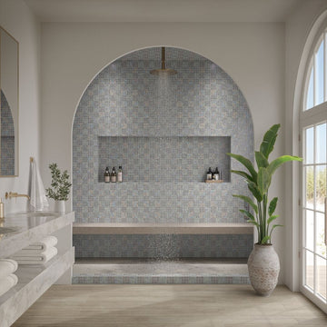 Modern bathroom with tiled shower area, sink, and plant