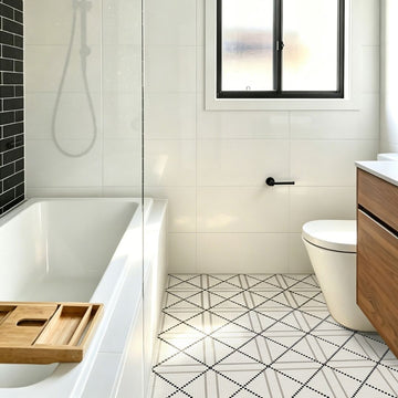 Calvin Bone Glass Mosaic Tile on a bathroom floor with a tub, sink and window