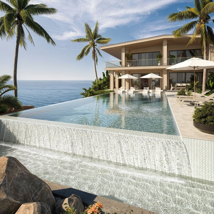 Luxury villa with an infinity pool overlooking the ocean, surrounded by palm trees.