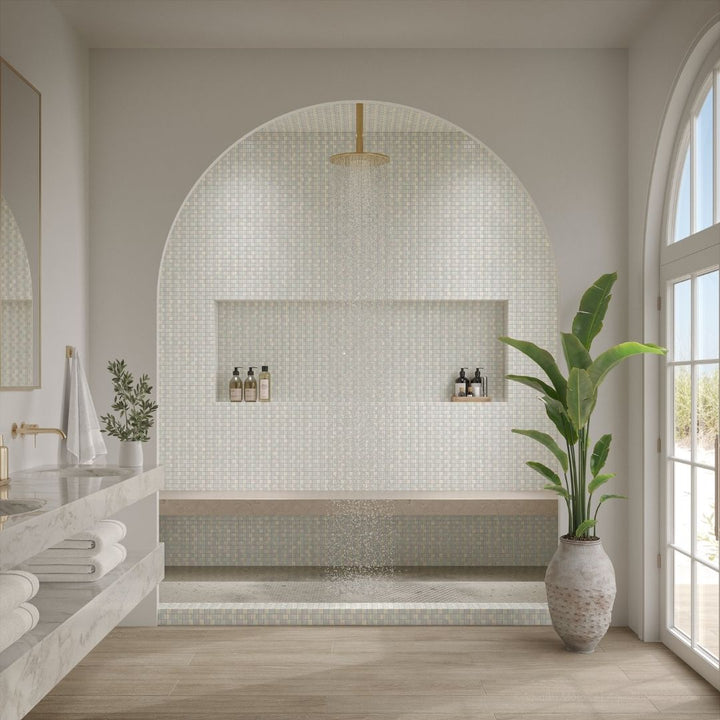 Modern bathroom with mosaic tile wall, plant, and natural light