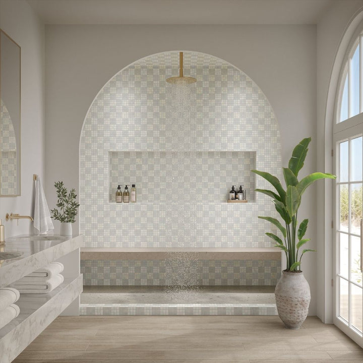 Modern bathroom with mosaic tile wall, plant, and natural light