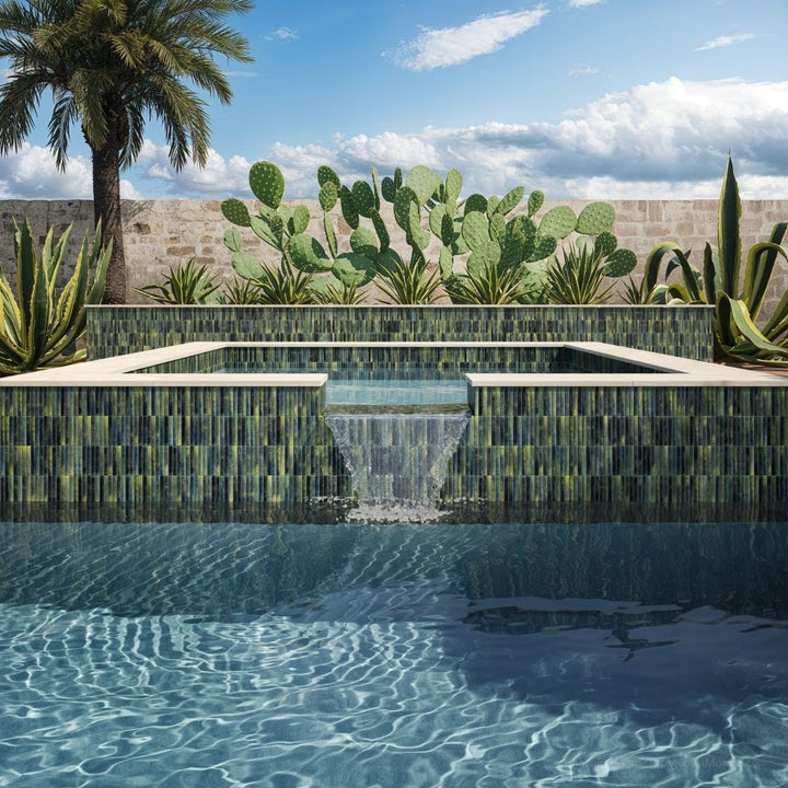 Modern pool with green tile walls and plants in the background