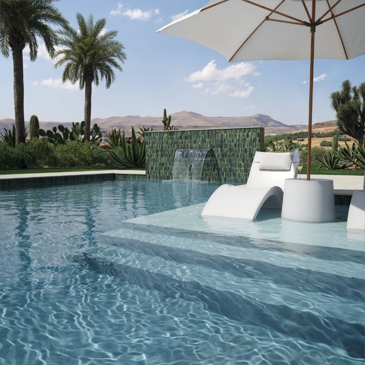 Pool area with lounge chairs, umbrella, and scenic background