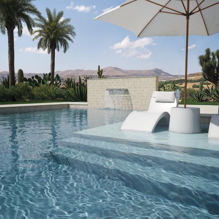 Pool area with lounge chairs, umbrella, and scenic background