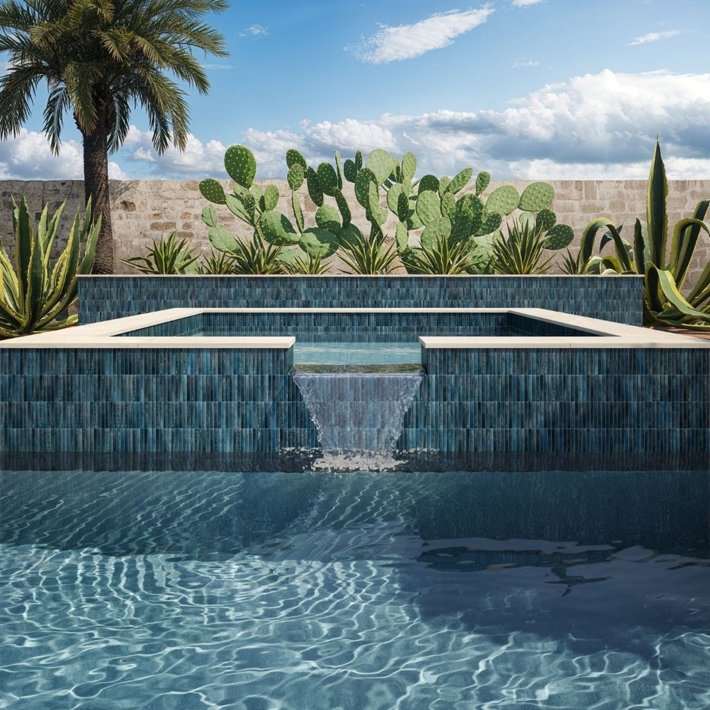 Modern pool with blue tiles surrounded by cacti and a palm tree under a clear sky.