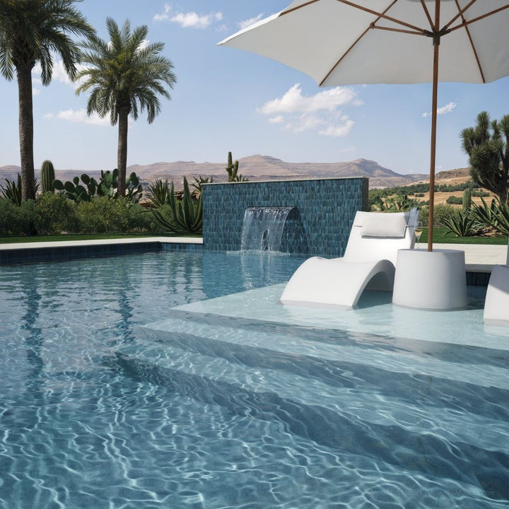 Pool area with lounge chairs, umbrella, and scenic background