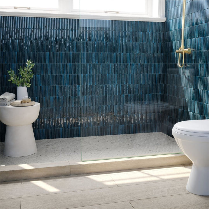 Modern bathroom with blue tiled walls and white fixtures