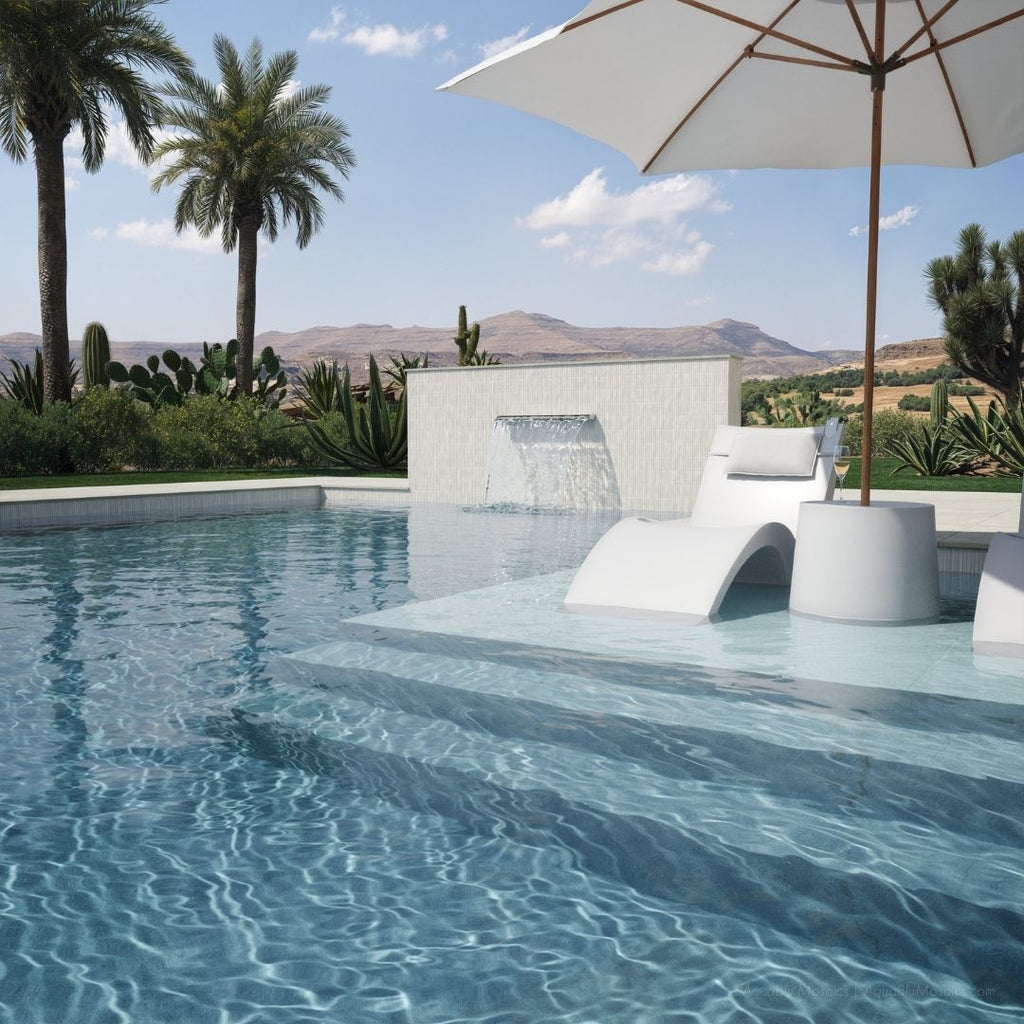 Pool area with lounge chairs, umbrella, and scenic background