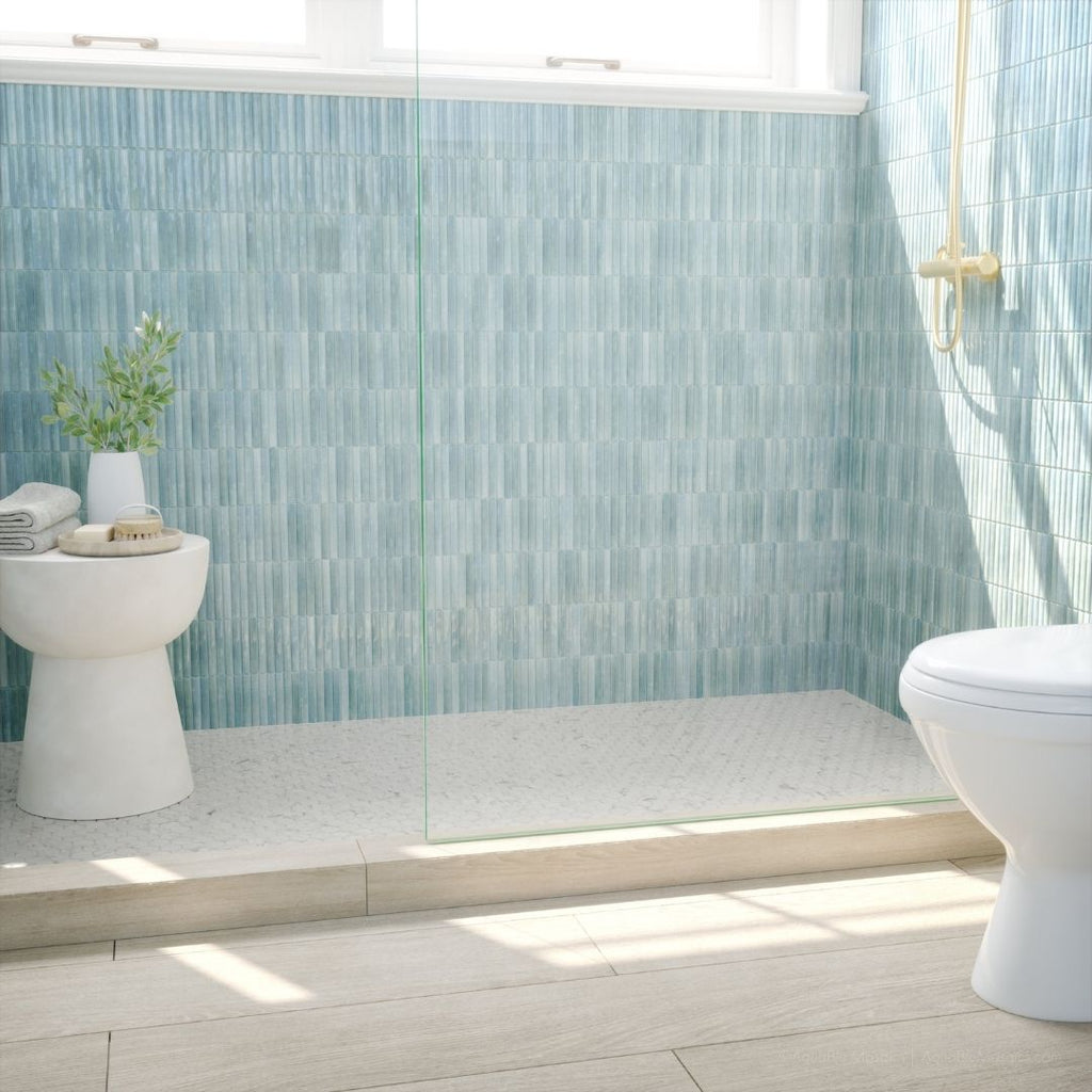 Bathroom with light blue tiled walls and a white toilet.