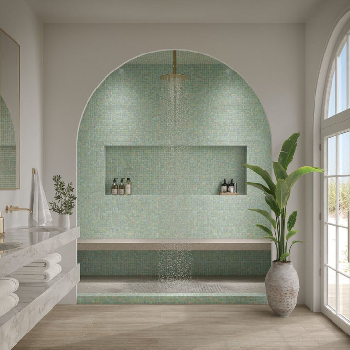Modern bathroom with mosaic tile wall, plant, and natural light
