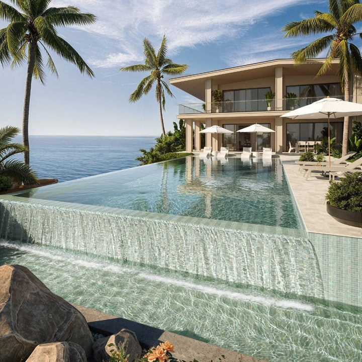 Luxury villa with an infinity pool overlooking the ocean, surrounded by palm trees.
