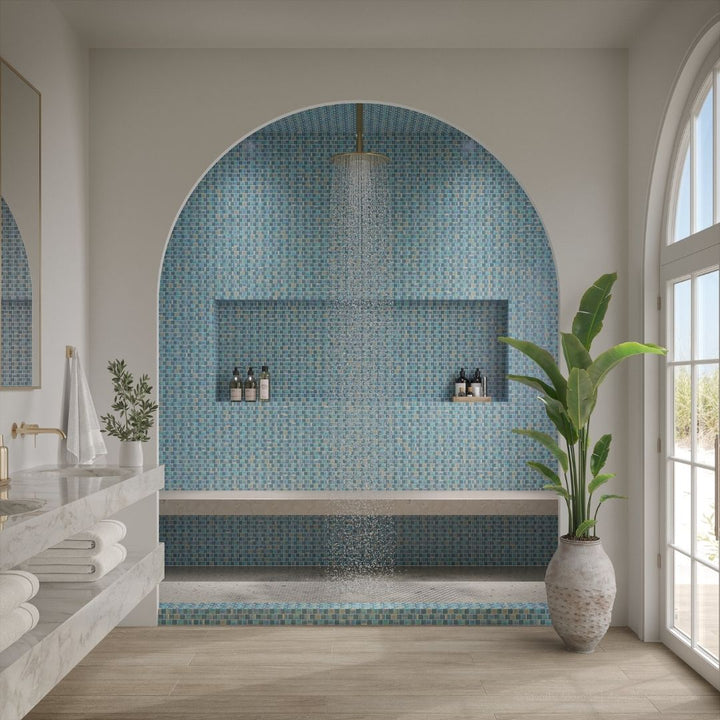 Modern bathroom with mosaic tile wall, plant, and natural light