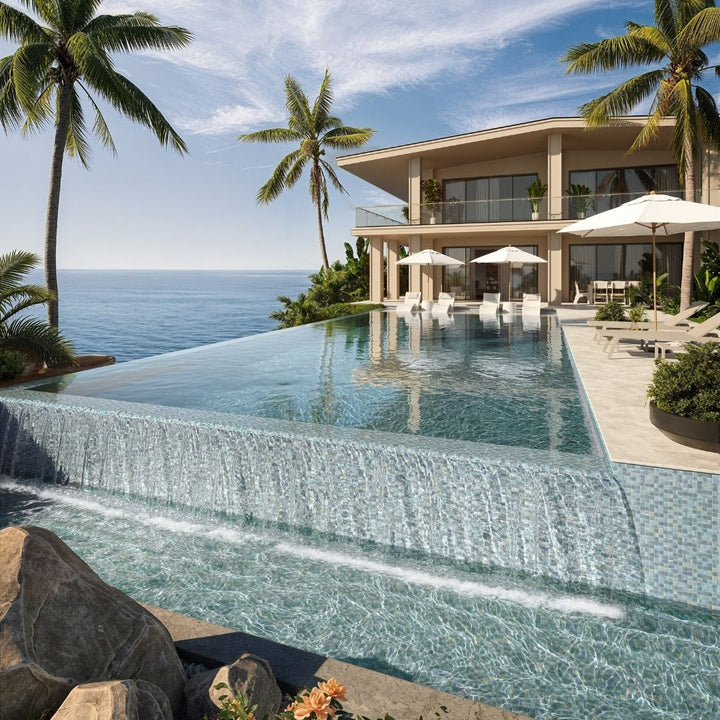 Luxury villa with an infinity pool overlooking the ocean, surrounded by palm trees.