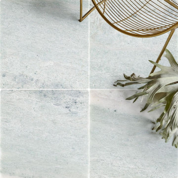 Ming Green Tumbled Marble Tile with chair and plant