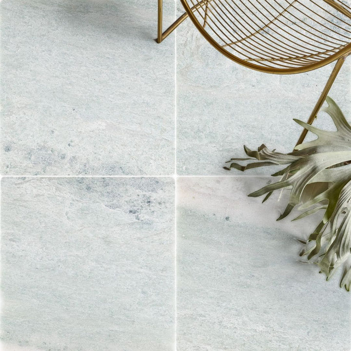 Ming Green Tumbled Marble Tile with chair and plant
