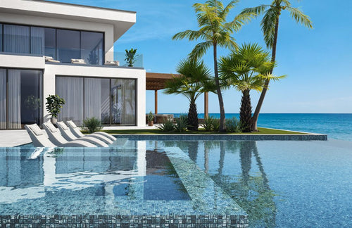 Blue mosaic glass tile in swimming pool with chairs and palm trees