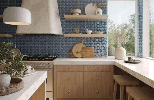 murrine mosaics blue glass tile in a kitchen with a stove, stools, and plants