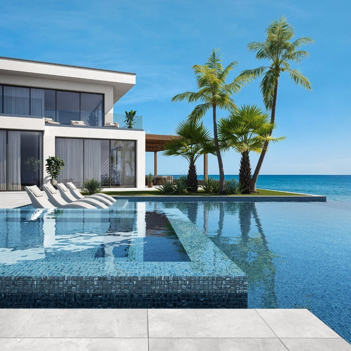 blue mosaic glass tile in swimming pool with chairs and palm trees