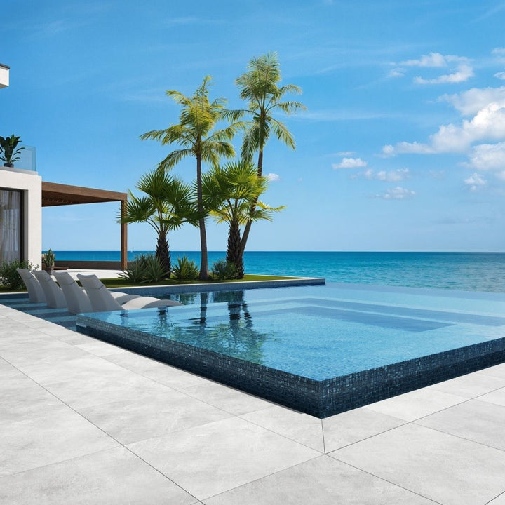 blue mosaic glass tile in swimming pool with chairs and palm trees