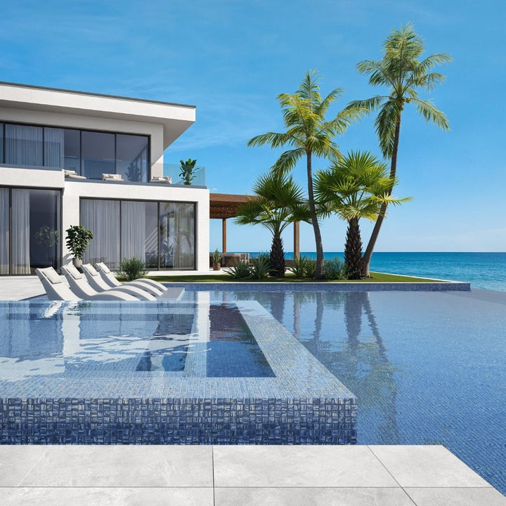 blue mosaic glass tile in swimming pool with chairs and palm trees