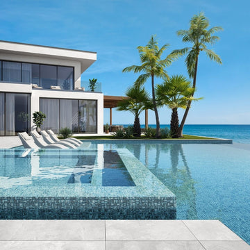 silver mosaic glass tile in swimming pool with chairs and palm trees