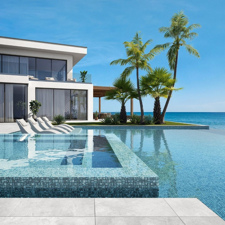 silver mosaic glass tile in swimming pool with chairs and palm trees