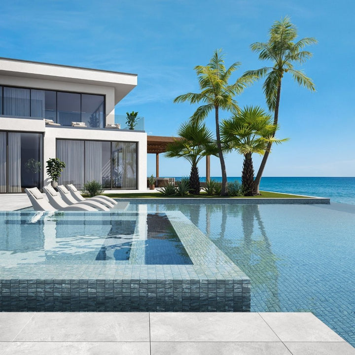 silver mosaic glass tile in swimming pool with chairs and palm trees