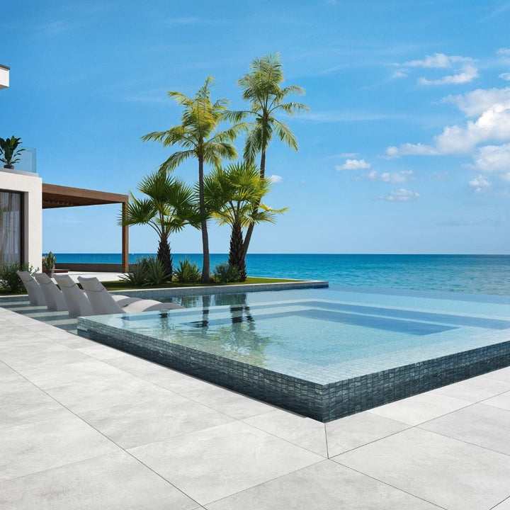 silver mosaic glass tile in swimming pool with chairs and palm trees