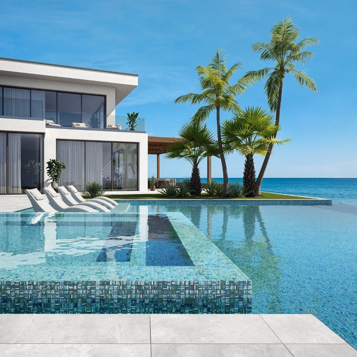 green mosaic glass tile in swimming pool with chairs and palm trees