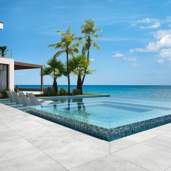 green mosaic glass tile in swimming pool with chairs and palm trees
