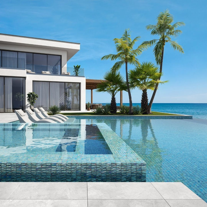 green mosaic glass tile in swimming pool with chairs and palm trees