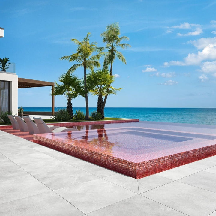red mosaic glass tile in swimming pool with chairs and palm trees